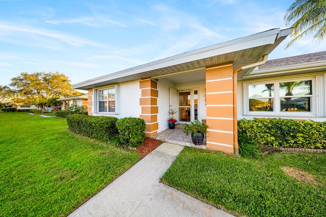 doorway to property with a lawn