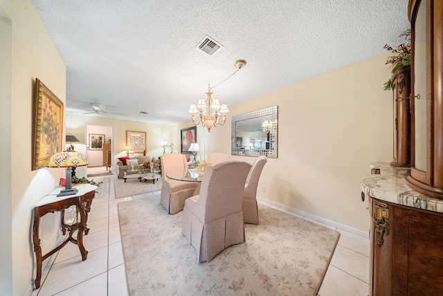 dining space with a textured ceiling, light tile patterned floors, and ceiling fan with notable chandelier