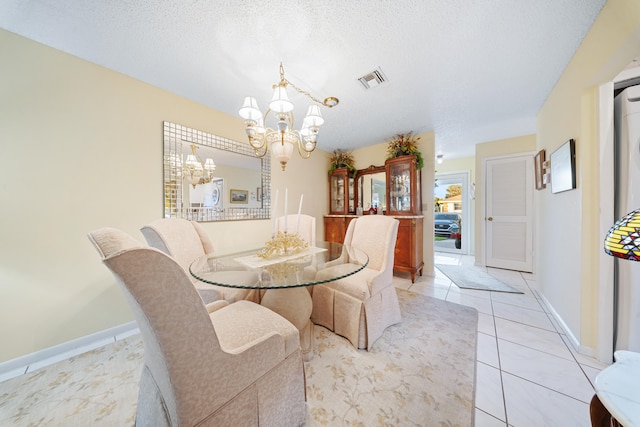 dining area featuring a textured ceiling, an inviting chandelier, and light tile patterned floors