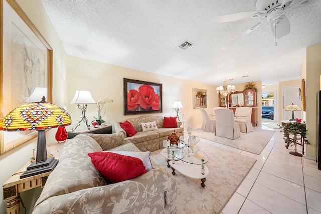 tiled living room with ceiling fan with notable chandelier and a textured ceiling