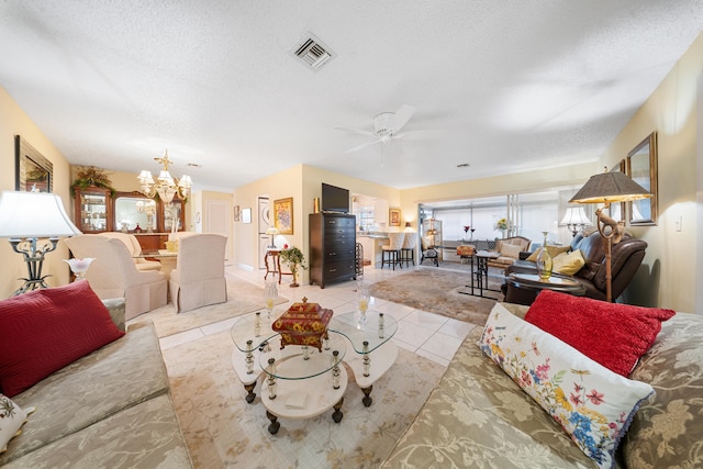 living room with light tile patterned floors, ceiling fan with notable chandelier, and a textured ceiling