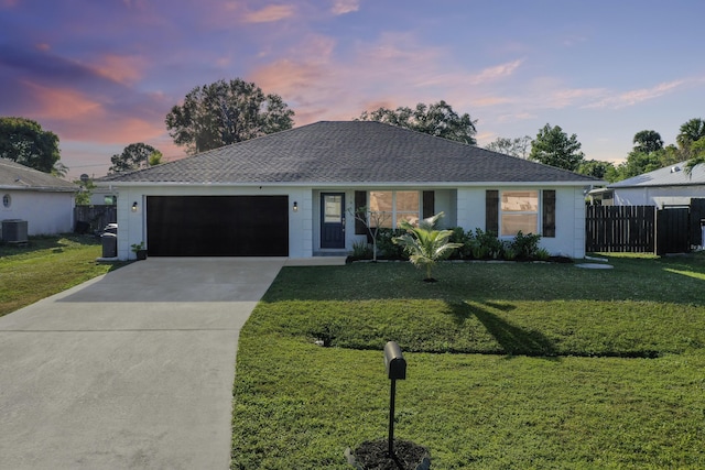 single story home with a garage, cooling unit, and a lawn