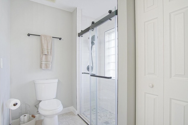 bathroom with toilet and a shower with shower door