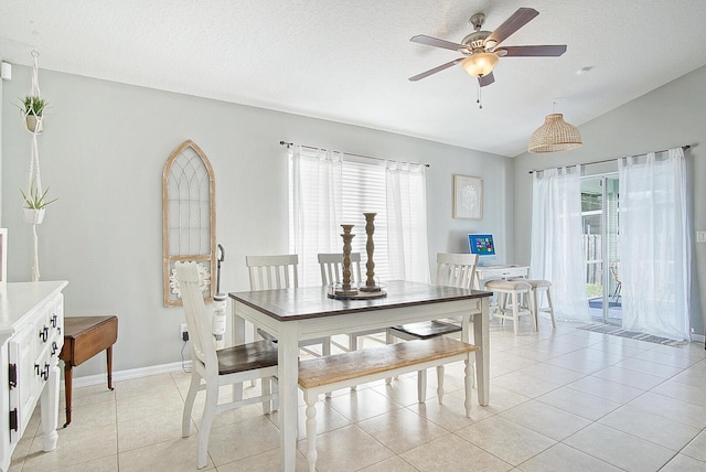 tiled dining room featuring vaulted ceiling, ceiling fan, plenty of natural light, and a textured ceiling