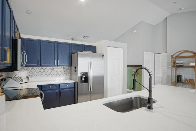 kitchen with lofted ceiling, stainless steel appliances, tasteful backsplash, sink, and blue cabinets