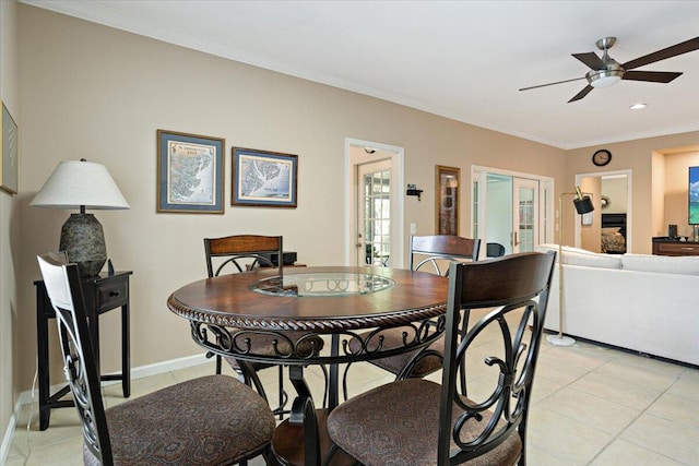 tiled dining space featuring crown molding and ceiling fan