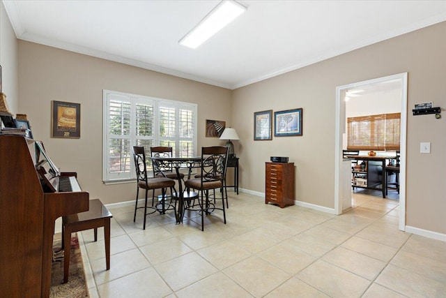 dining area featuring baseboards, light tile patterned flooring, and crown molding