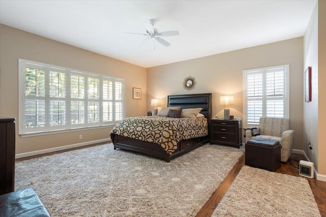 bedroom with a ceiling fan, baseboards, and wood finished floors