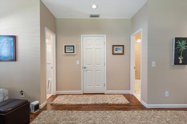 entrance foyer with wood finished floors, visible vents, and baseboards