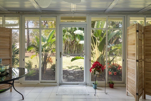 doorway to outside with floor to ceiling windows and light tile patterned flooring