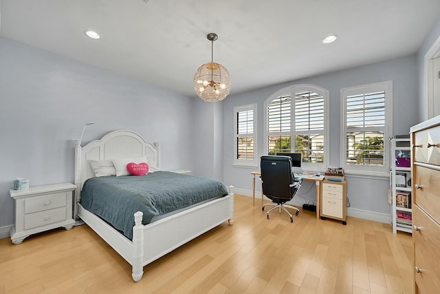 bedroom featuring multiple windows, light hardwood / wood-style flooring, and an inviting chandelier