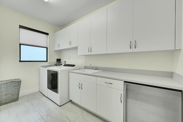 washroom with cabinets, sink, and washing machine and clothes dryer