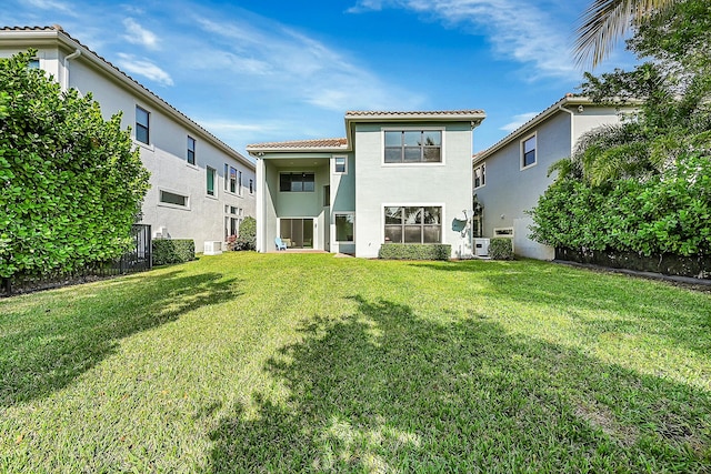 back of property with a yard and ac unit