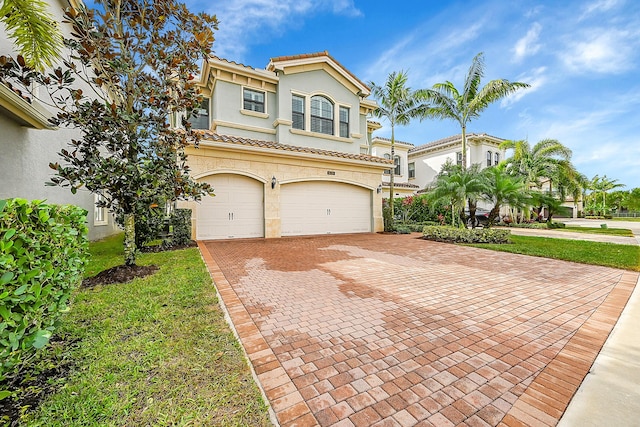 mediterranean / spanish-style house with a garage and a front lawn