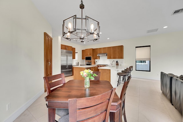 tiled dining room with sink and a chandelier