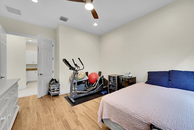 bedroom with ceiling fan, connected bathroom, and light wood-type flooring