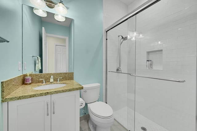 bathroom featuring vanity, toilet, and a shower with shower door