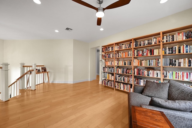 living area with ceiling fan and light hardwood / wood-style floors