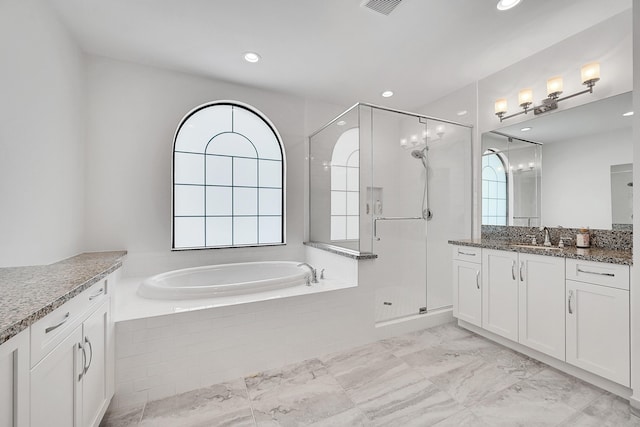 bathroom featuring vanity and independent shower and bath