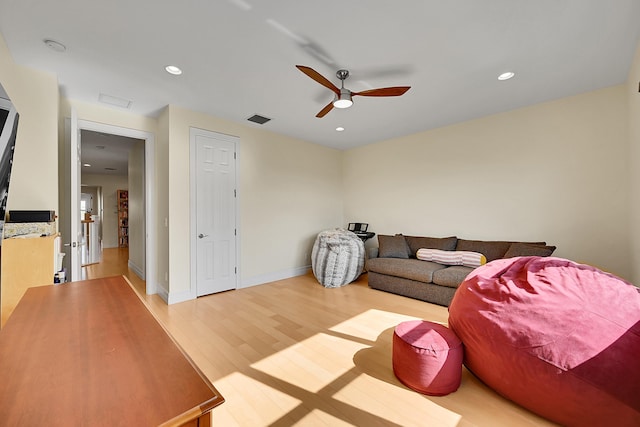 living room with hardwood / wood-style floors and ceiling fan