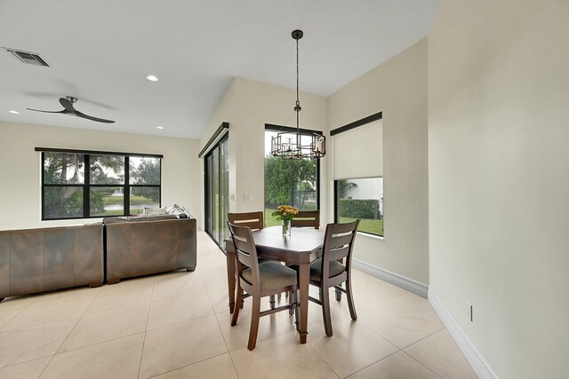 tiled dining area featuring ceiling fan with notable chandelier and plenty of natural light