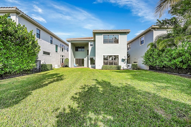 rear view of property with a yard and ac unit