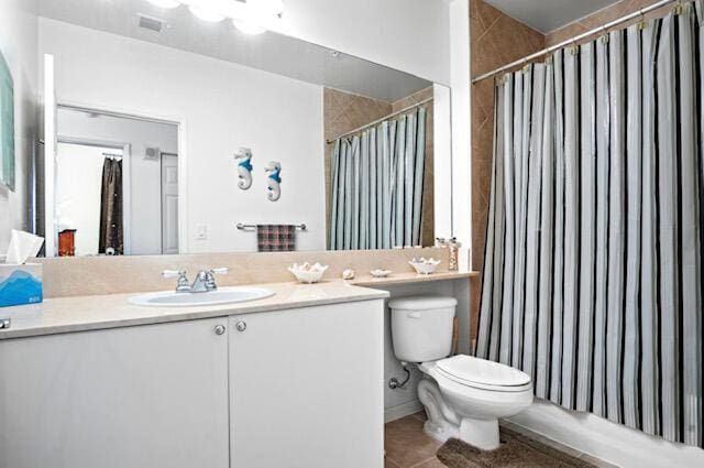 full bathroom with tile patterned floors, toilet, vanity, and shower / bath combination with curtain