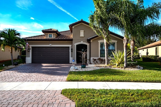 mediterranean / spanish home with a front yard and a garage