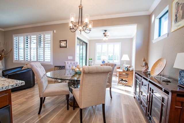 dining space featuring light hardwood / wood-style floors, an inviting chandelier, a wealth of natural light, and ornamental molding