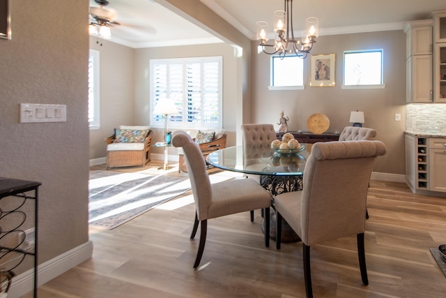 dining area featuring ceiling fan with notable chandelier, light hardwood / wood-style flooring, and crown molding