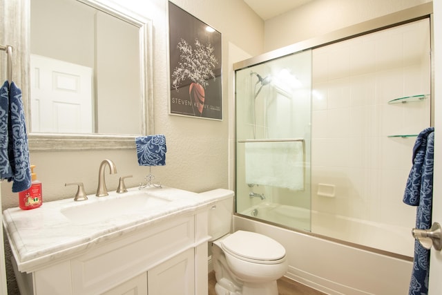 full bathroom featuring vanity, shower / bath combination with glass door, and toilet