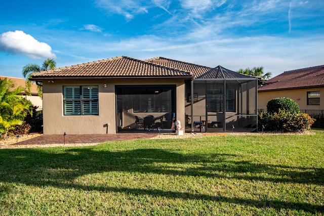 back of property with glass enclosure and a lawn