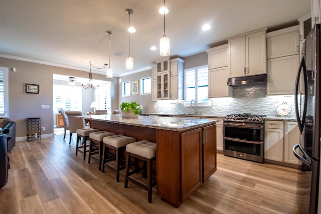 kitchen featuring a kitchen island, double oven range, decorative light fixtures, and crown molding