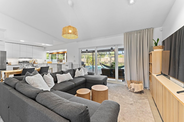 living room with vaulted ceiling and light colored carpet