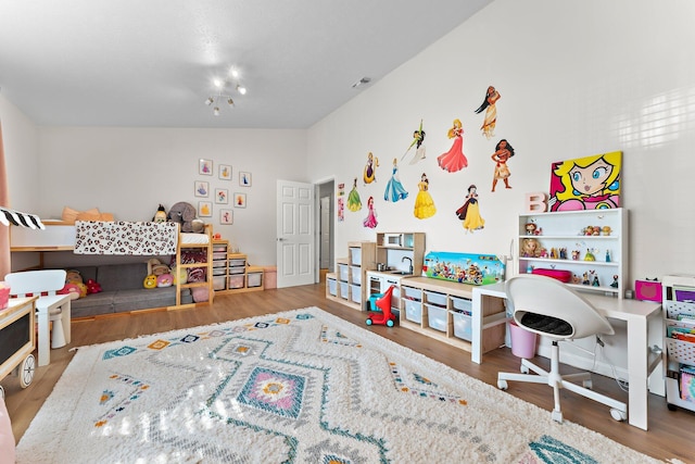 playroom with lofted ceiling, wood finished floors, and visible vents