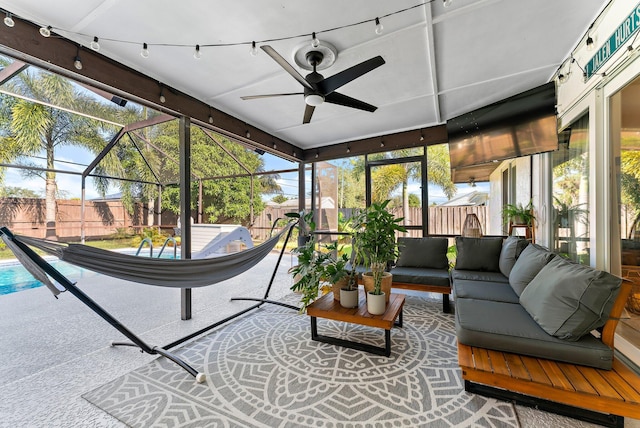 sunroom / solarium featuring a ceiling fan, a wealth of natural light, and track lighting