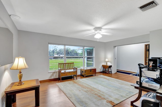 office space with ceiling fan, a textured ceiling, and hardwood / wood-style floors