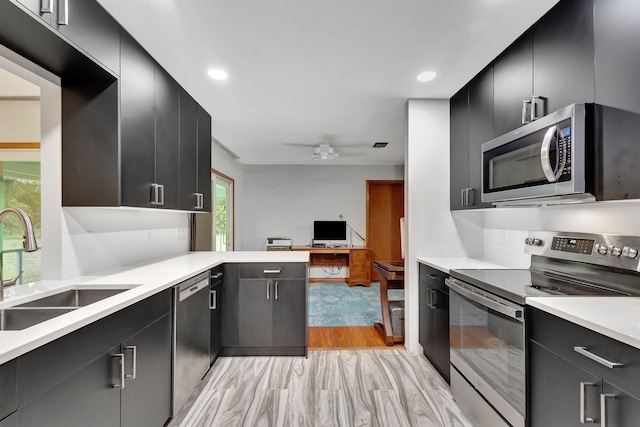 kitchen with ceiling fan, sink, appliances with stainless steel finishes, and light wood-type flooring