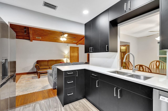 kitchen featuring ceiling fan, dishwasher, light hardwood / wood-style floors, kitchen peninsula, and sink