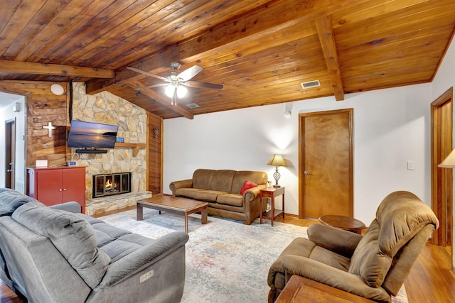 living room with ceiling fan, a fireplace, lofted ceiling with beams, light hardwood / wood-style flooring, and wood ceiling