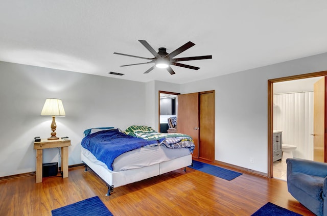 bedroom with ceiling fan, connected bathroom, and light hardwood / wood-style flooring