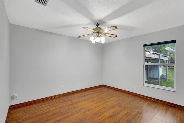 unfurnished room with hardwood / wood-style flooring, ceiling fan, a textured ceiling, and plenty of natural light