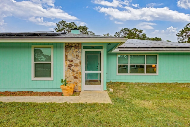 view of front of house with a front yard and solar panels