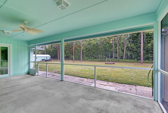 unfurnished sunroom featuring ceiling fan