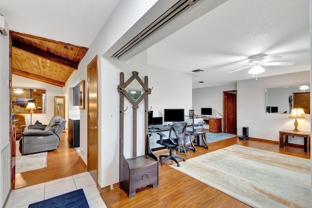 office featuring ceiling fan, light hardwood / wood-style floors, vaulted ceiling with beams, a textured ceiling, and wooden ceiling