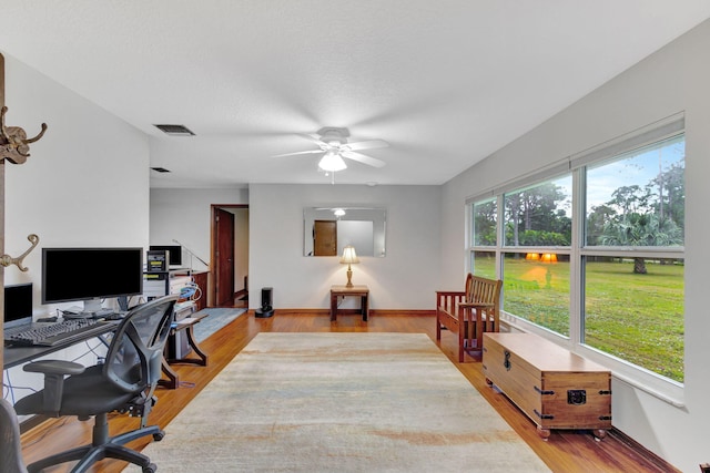 home office featuring ceiling fan, plenty of natural light, and hardwood / wood-style floors