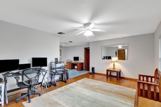 office space featuring ceiling fan, a textured ceiling, and light hardwood / wood-style flooring