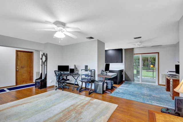 office space with a textured ceiling, ceiling fan, and light hardwood / wood-style flooring