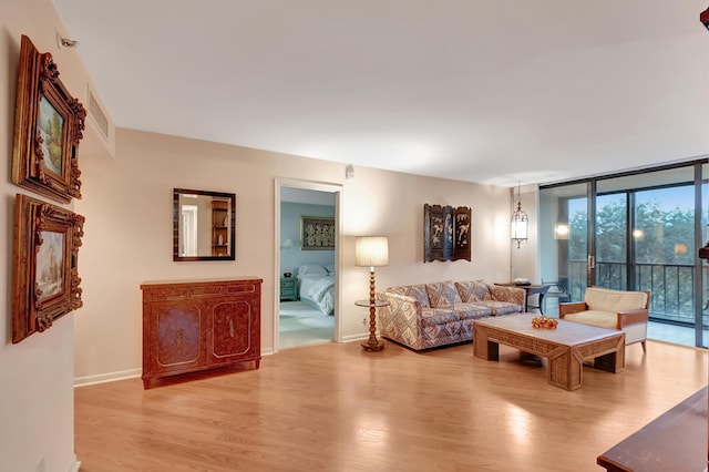 living room with floor to ceiling windows and light hardwood / wood-style flooring