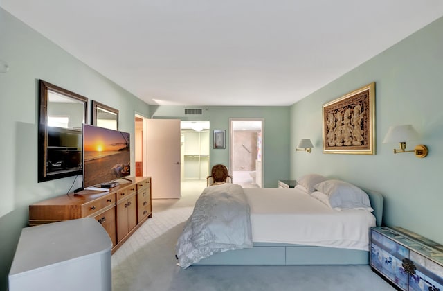 bedroom with light carpet and ensuite bath